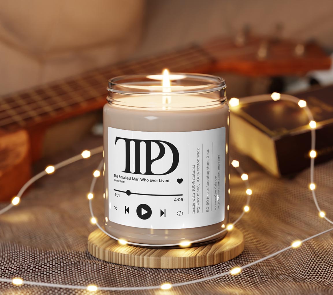 Taylor Swift Candle - The Smallest Man Who Ever Lived 9oz. Scented Candle. Available in clean cotton, Sea Sal + orchid, White Sage + Lavender, Apple Harvest, Cinamon Vanilla, Atlantis Whisper, Christmas Warmth, Coconut Cream + Cardamom, Peppered Passionfruit and Unscented Front View Lit